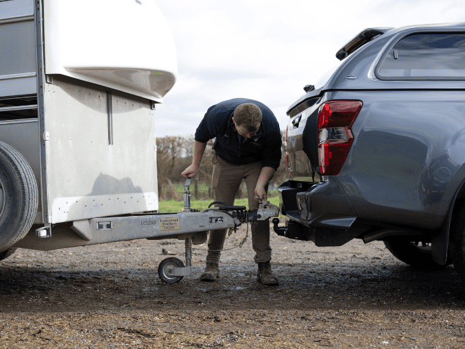 Farmer hitching up a trailer to a pick-up ready for towing
